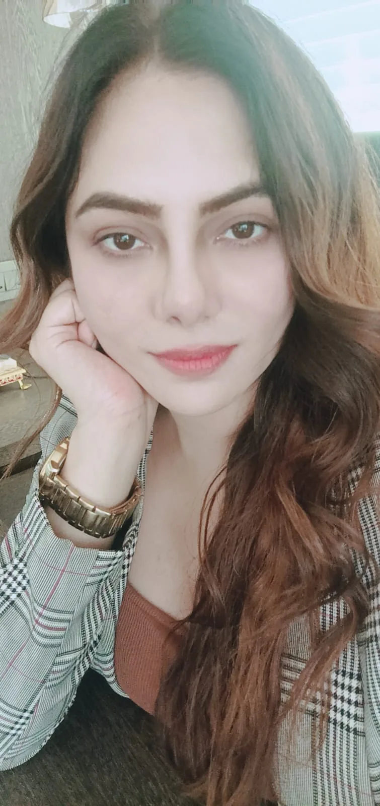 Vibha Jain, hypnotherapist, resting her chin on her hand and looking directly at the camera.